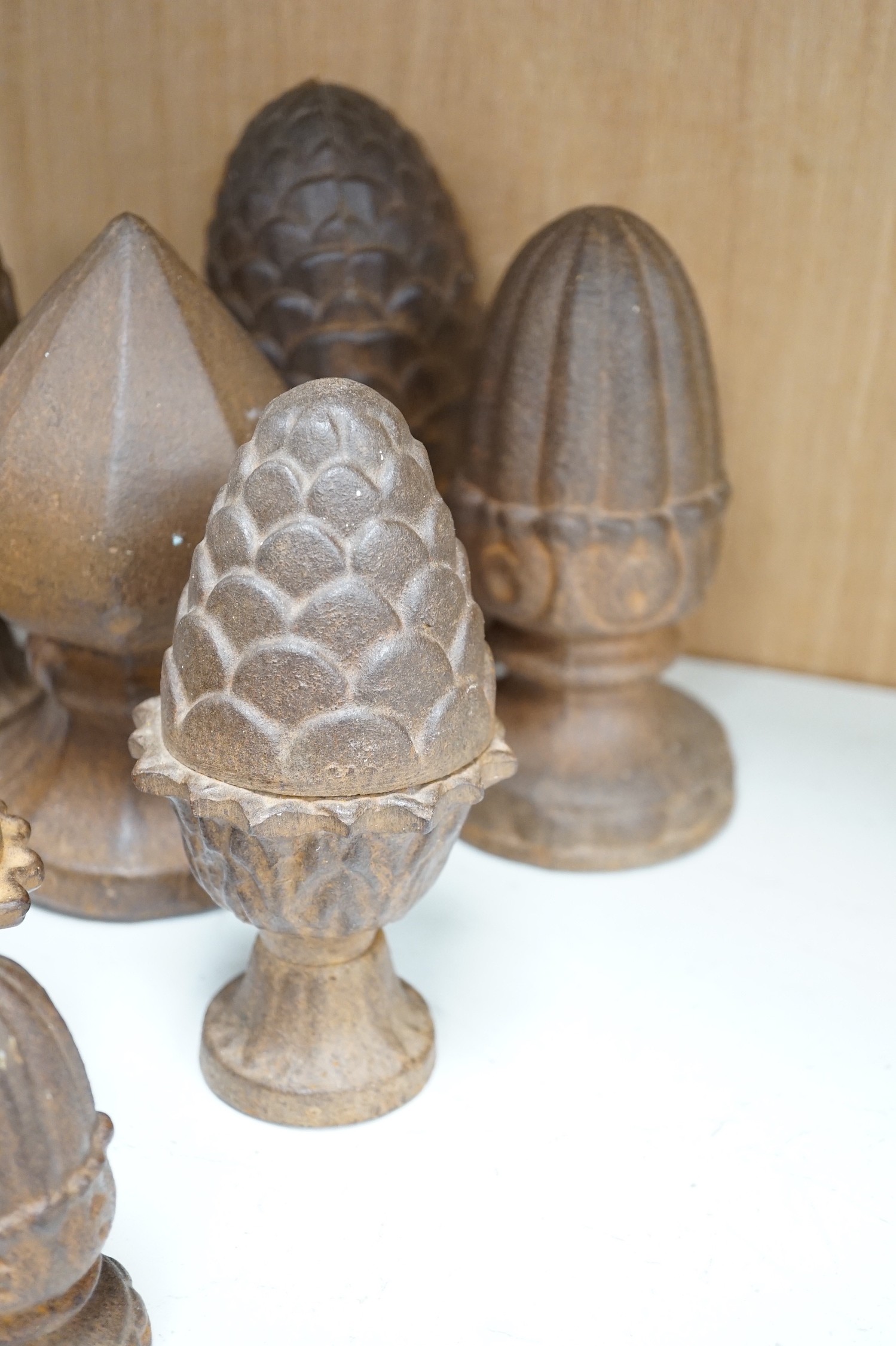 A group of cast iron finials, some with pine-cone decoration, tallest 21cm